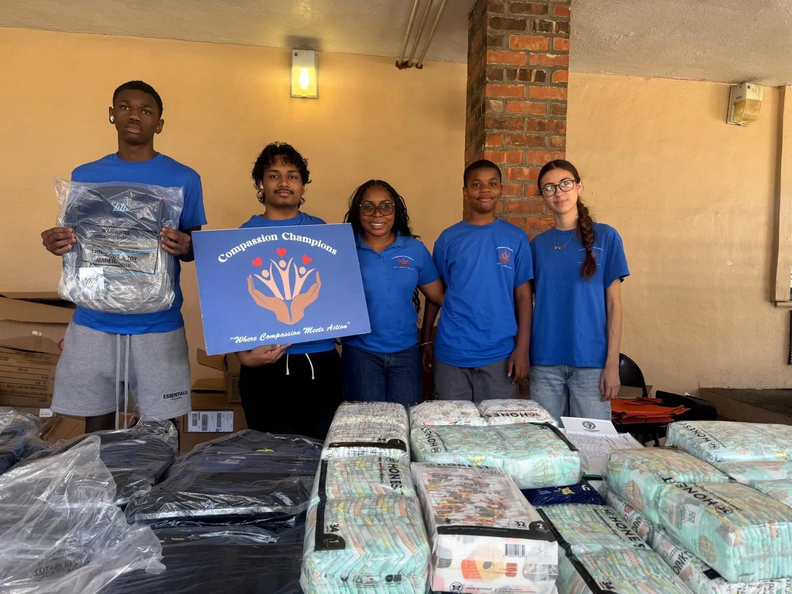 The volunteer team lined up behind tables of backpacks and supplies