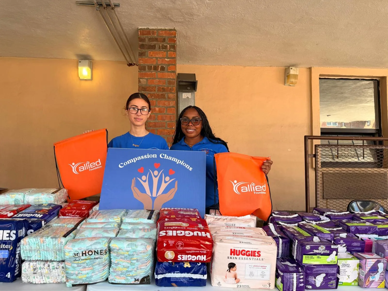 Volunteers with donated supplies and baby items